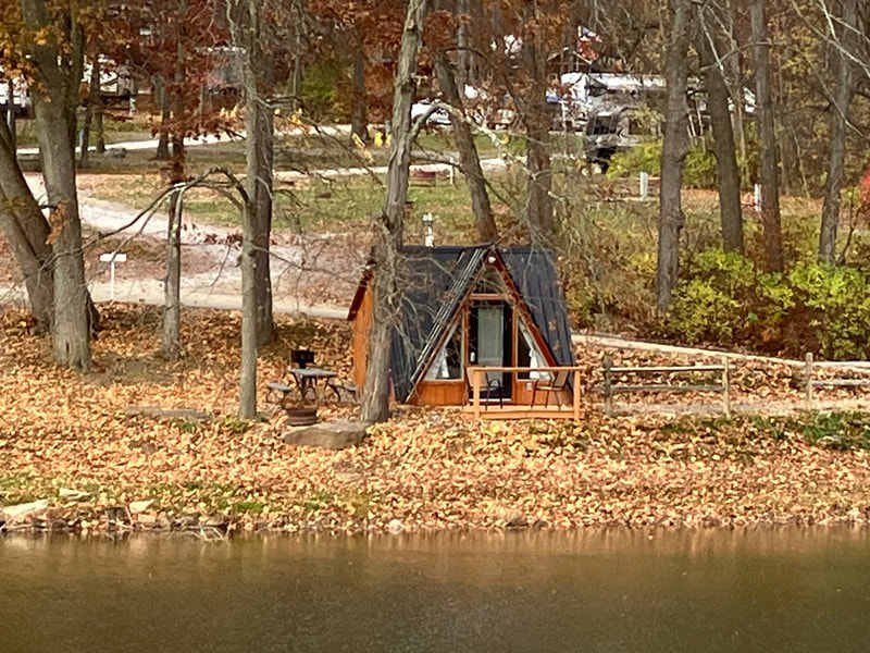 Silver Canoe Campground A-frame cabin viewed from across the pond in autumn